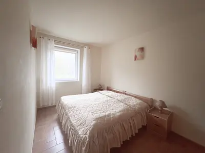 Sypialnia z podwójnym łóżkiem i oknem z widokiem na ogród — Brogi