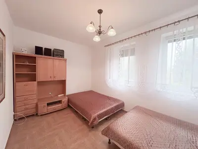 Pokój z dwoma łóżkami pojedynczymi i drewnianą szafą z żyrandolem