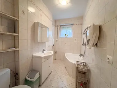 Łazienka z białą wanną, umywalką i oknem w domu w Brogach k. Łodzi