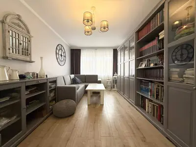 Pokój biblioteka z szarymi regałami, sofą i parkietem — mieszkanie Łódź-Polesie 102 m²