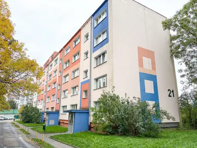 Czteropiętrowy budynek mieszkalny z kolorowymi elewacjami w Łodzi.