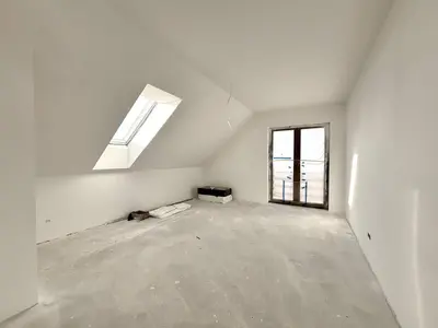 Pokój na poddaszu ze skośnym sufitem i oknem połaciowym — stan deweloperski