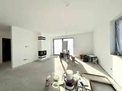 Stan deweloperski salonu z kominkiem narożnym i panoramicznym oknem tarasowym