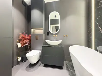 Łazienka z wolnostojącą wanną, szarym marmurem i złotą armaturą — centrum Łodzi