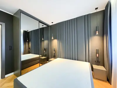 Sypialnia z tapicerowanymi panelami ściennymi i szafą z lustrem — mieszkanie Łódź centrum