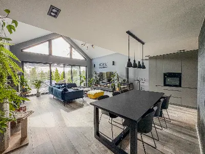 Salon z jadalniÄ i aneksem kuchennym, wysokie przeszklenia trÃ³jkÄtne w domu we Wronowicach