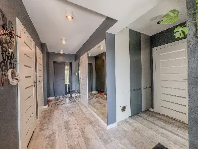 Przestronny hol wejÅciowy z lustrem i nowoczesnymi drzwiami w domu we Wronowicach