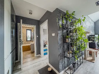 Korytarz z metalowym regaÅem na roÅliny i widokiem na ÅazienkÄ w domu we Wronowicach