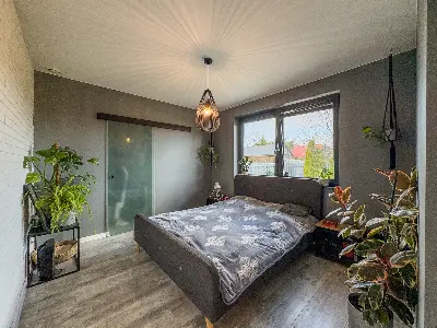 Sypialnia gÅÃ³wna ze szklanymi drzwiami przesuwnymi i roÅlinami w domu we Wronowicach