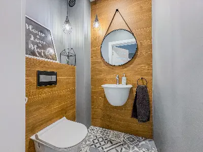 Toaleta goÅcinna z okrÄgÅym lustrem i pÅytkami patchwork w domu we Wronowicach