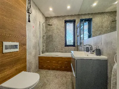 Åazienka z wannÄ, prysznicem deszczowym i pÅytkami imitujÄcymi drewno w domu we Wronowicach