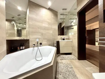 Luksusowa łazienka z wolnostojącą wanną, dużymi lustrami i marmurowymi płytkami