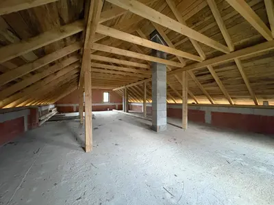 Przestrzeń poddasza z drewnianą więźbą dachową gotową do adaptacji
