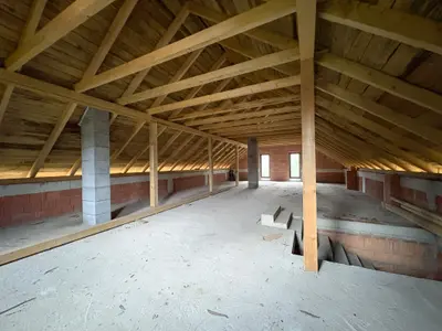 Poddasze z drewnianą konstrukcją więźby dachowej — widok na całą przestrzeń