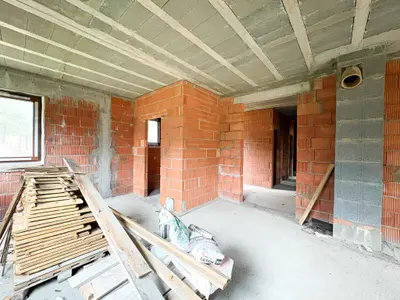 Wnętrze w stanie surowym — przestrzeń dzienna z widocznym układem ścian