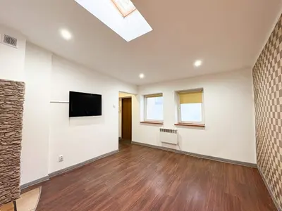 Jasny pokój dzienny z balkonem i drewnianą podłogą — kawalerka Łódź Bałuty 26m²